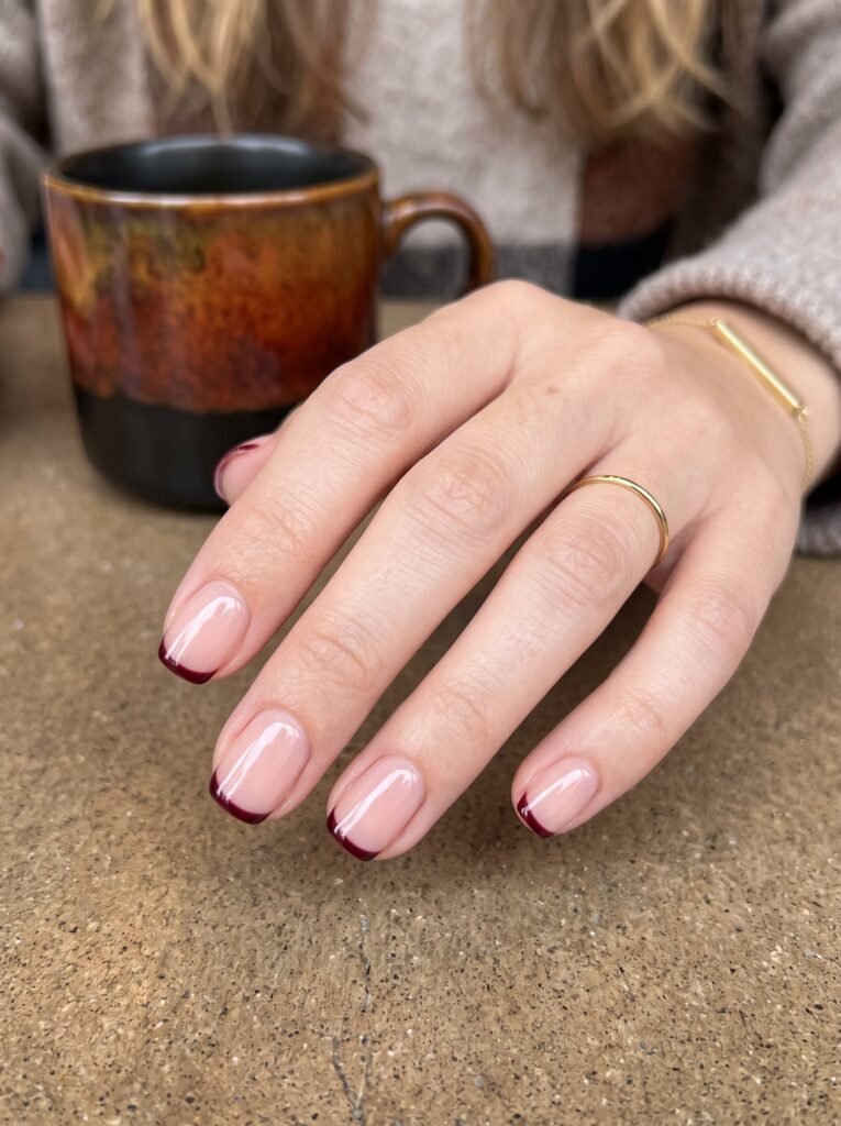 Deep oxblood wine micro-French tips featuring minimalist burgundy fall nails West Loop at NailàCarte.