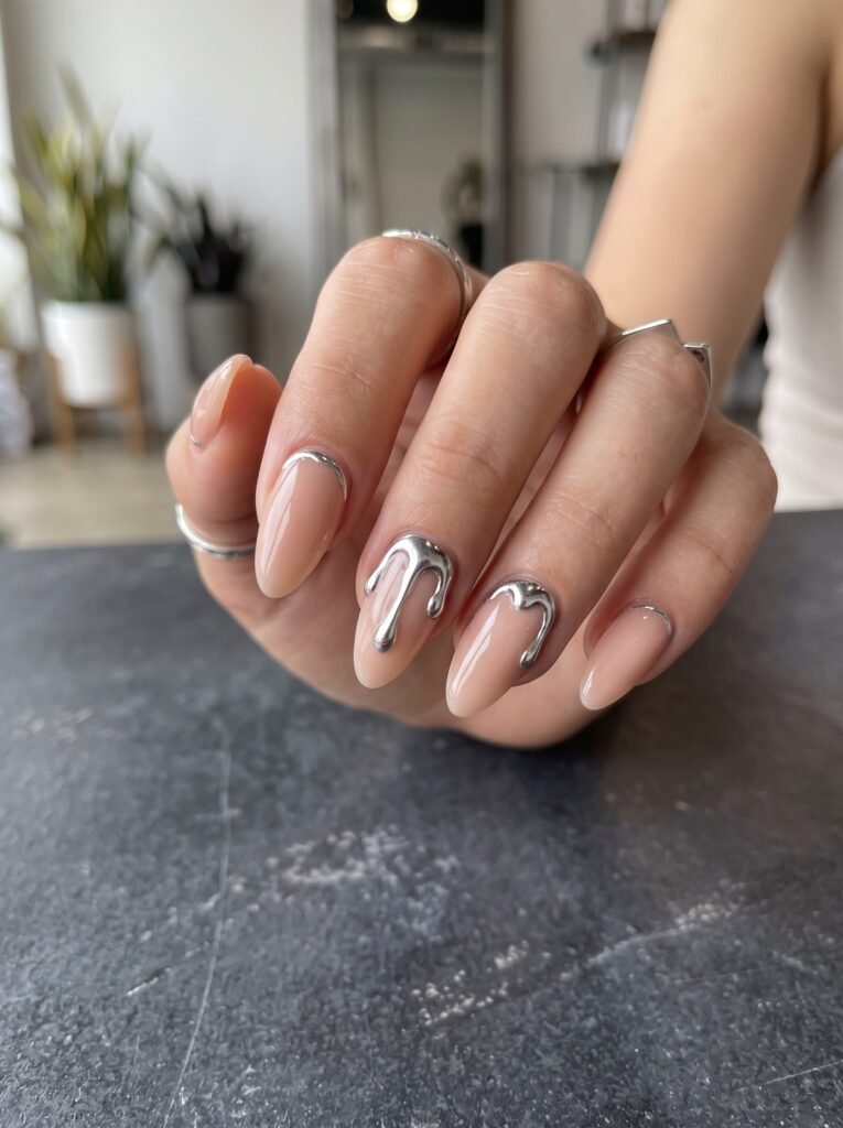 Molten silver 3D liquid metal drips on nude BIAB for futuristic september nail ideas Wicker Park.