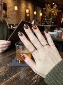 Glass-like rich amber tortoiseshell accent nail art highlighting artistic fall nail colors west loop.