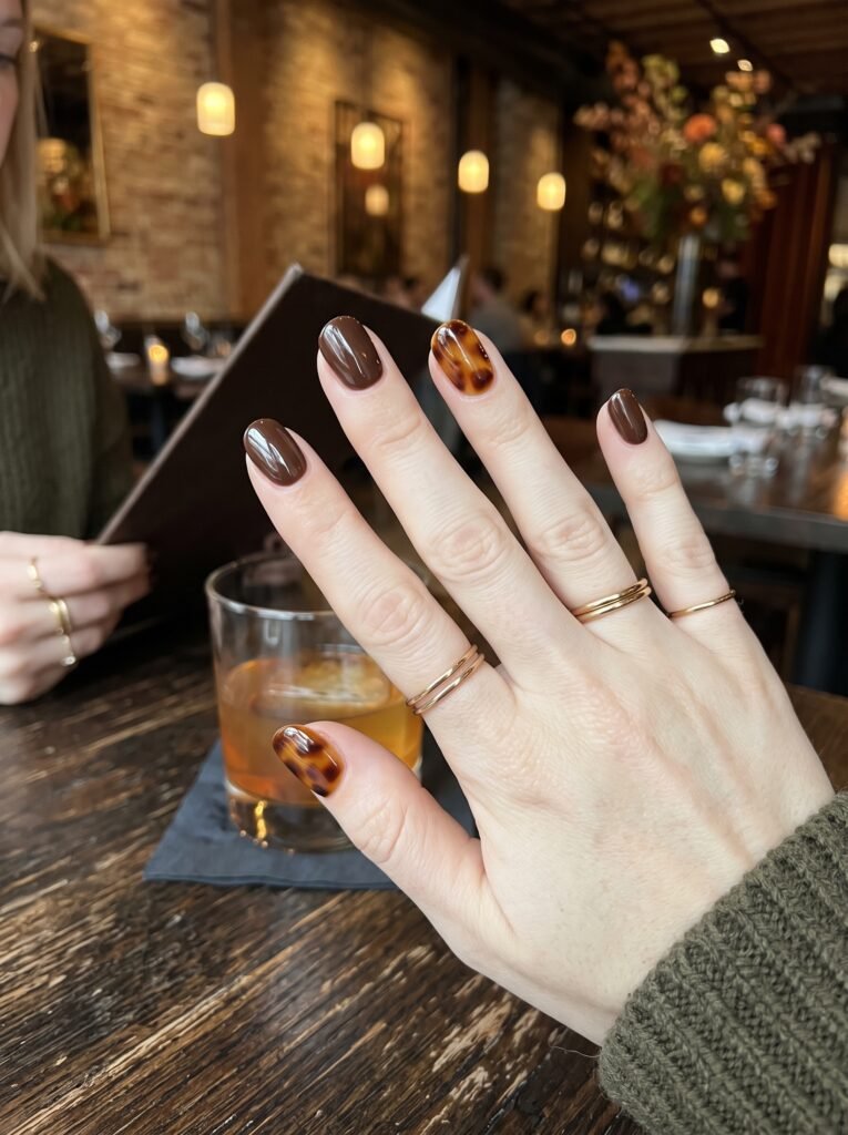 Glass-like rich amber tortoiseshell accent nail art highlighting artistic fall nail colors west loop.