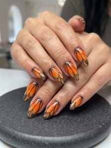 Burnt orange Monarch butterfly wing design showcasing top nail colors for fall 2026 at NailàCarte.